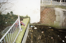 108628 Afbeelding van een meisje dat bij de inlaat van de Koekoeksvaart langs de Nieuwe Keizersgracht voorwerpen uit ...